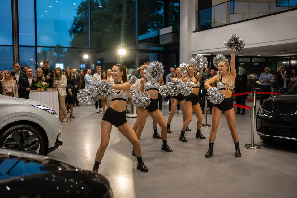 Grupa taneczna z pomponami występuje w nowym salonie samochodowym przed gośćmi otwarcia